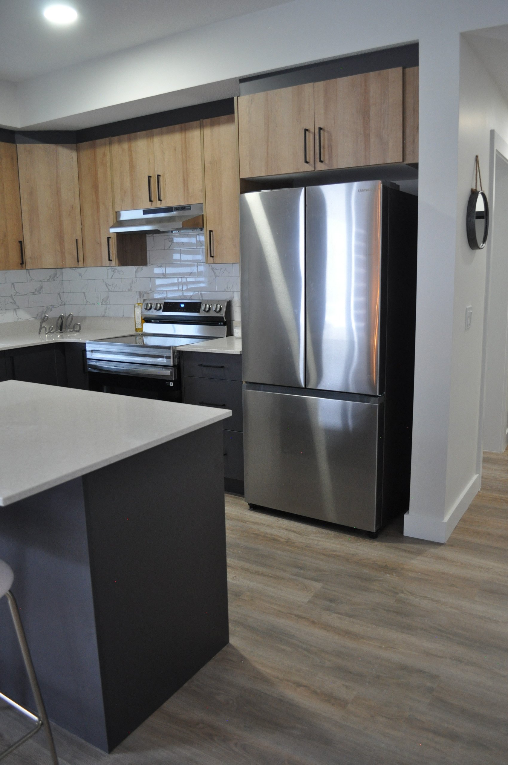 A modern kitchen with a refrigerator, stove, and cabinets.